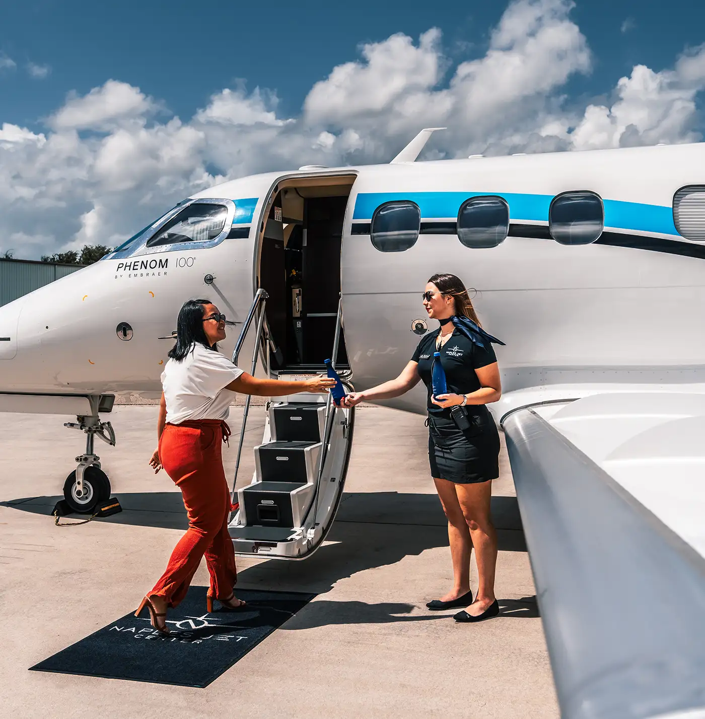Women boarding private jet with stewardess